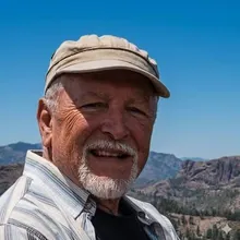 Juan Ramón Rodríguez, con gorra y barba blanca, sonriendo en una cumbre de Gran Canaria.